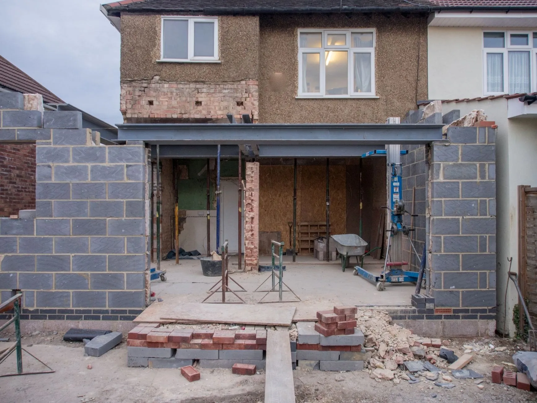 The back wall of a semi-detached house opened up on a steel beam, with new blockwork walls either side