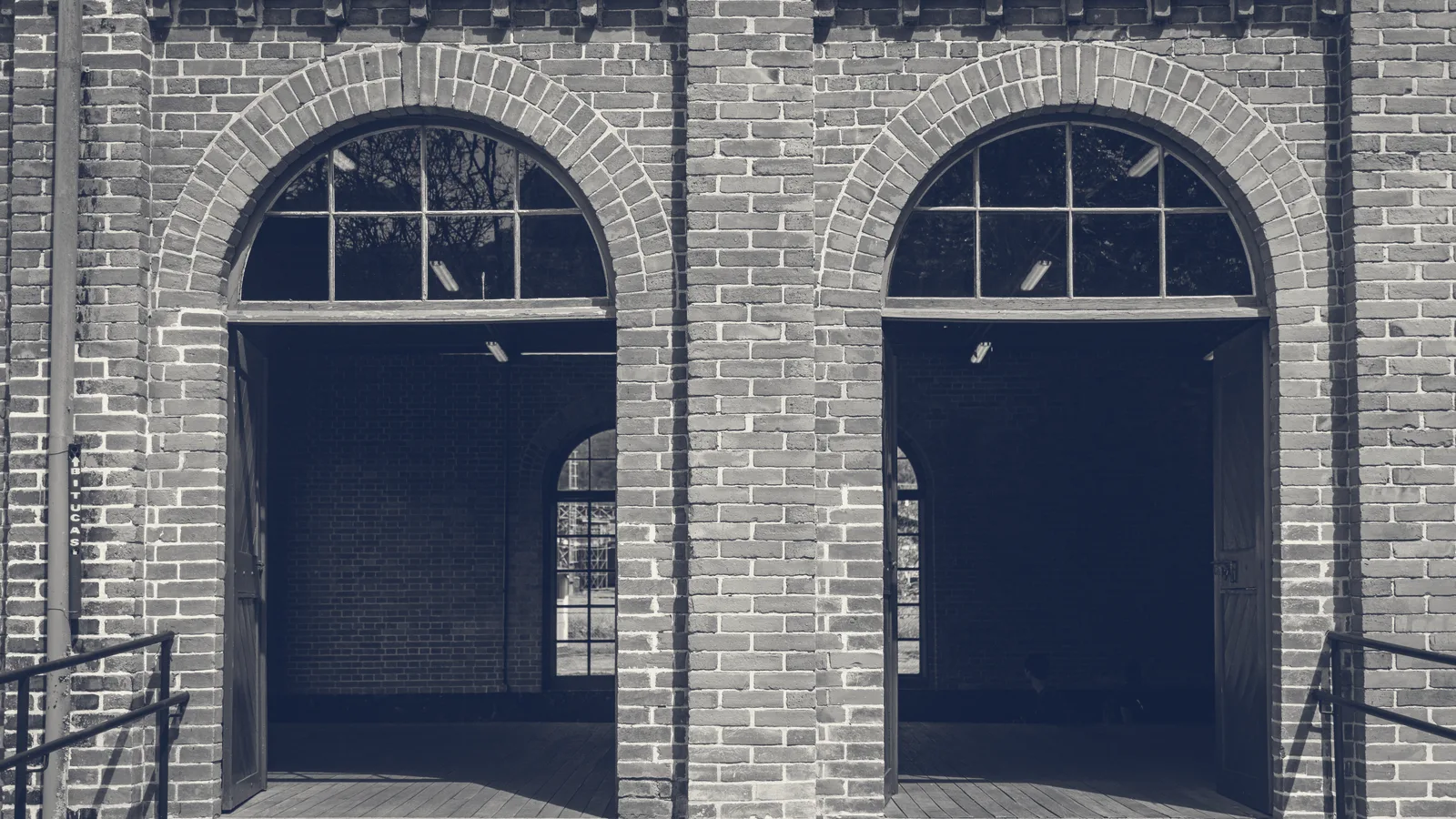 A newly built segmental brick arch over a wide ground-floor opening