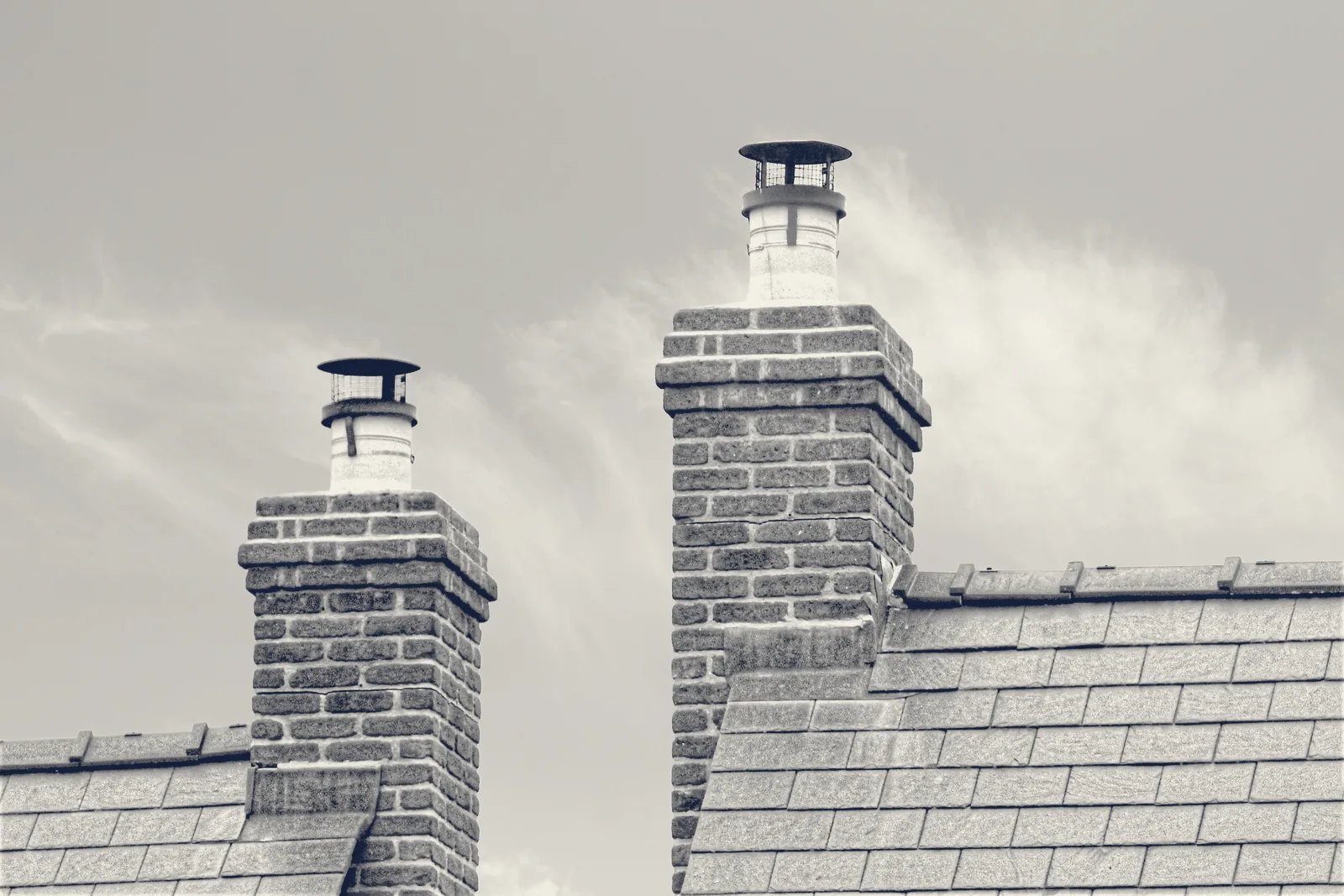 A rebuilt brick chimney stack against a grey sky
